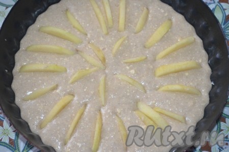 Вылить тесто в смазанную маслом форму. По кругу выложить дольки яблок.