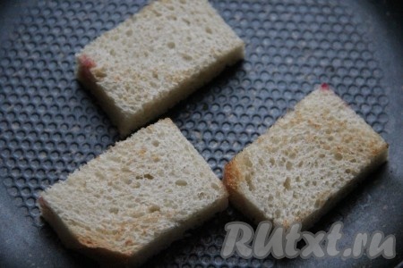 Каждый ломоть белого (или чёрного) хлеба разрезать на 2 части, отрезать корочки. Из каждого ломтика получатся 2 прямоугольные заготовки бутербродов. Подрумянить их с двух сторон на сухой сковороде. Можно подсушить ломти хлеба в тостере, а затем обрезать корочки и разрезать пополам. Подрумяненный хлеб тщательно натереть очищенным зубчиком чеснока с одной стороны.