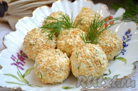 Аппетитные, вкусные сырные шарики в кунжуте выложить на блюдо, украсить, по желанию, зеленью и подать к столу.