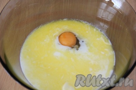 Масло растопить и остудить. В глубокую миску влить молоко, добавить яйцо и растопленное масло.
