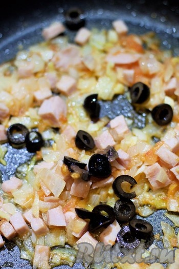 Осталось добавить оливки, нарезанные произвольным образом. Обжаривайте содержимое сковороды 5 минут.
