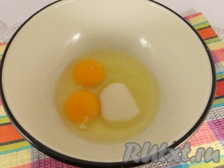 В миску разбить яйца, добавить соль и сахар.
