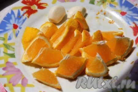 Апельсины тщательно вымыть. Из 1,5-2 апельсинов выдавить 100 миллилитров сока. Залить ножки свежевыжатым соком и оставить минут на 15, за это время их нужно будет 2-3 раза перемешать, чтобы они равномерно пропитались соком. Отдельно в тарелку нарезать оставшийся вымытый, неочищенный от кожуры апельсин. Чеснок очистить и нарезать на пластины.
