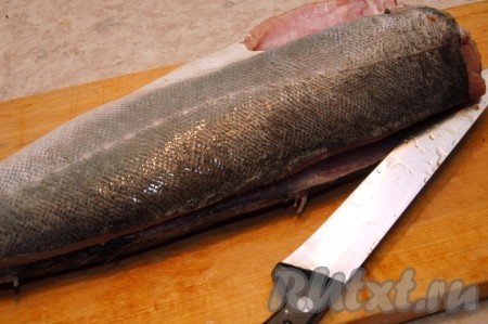 Подрезая ножом вдоль хребта, разделать рыбу на филе.