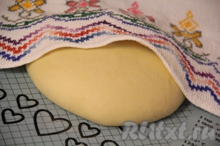 Поднявшееся сдобное творожное тесто для булочек достать из хлебопечки, хорошо обмять и оставить на столе под полотенцем на 30-40 минут.