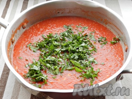 Через 15 минут добавить в томатный соус мелко порубленные листья базилика и специи. Перемешать и готовить еще 15 минут.

