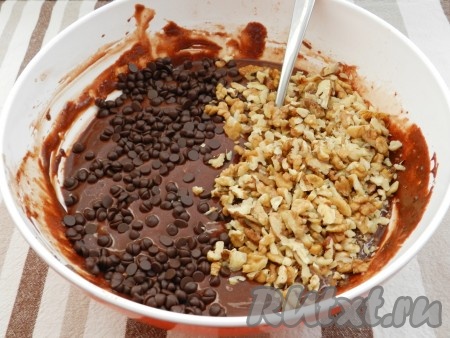 Грецкие орехи нарезать не очень мелко и добавить в миску с тестом. По желанию, можно выложить  ещё шоколадные капли или дроблёный шоколад. Перемешать.