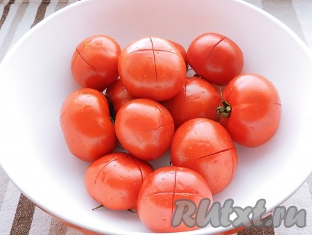 Сложить помидоры в глубокую миску. Сделать на них крестообразные надрезы со стороны, противоположной плодоножке. Залить помидоры кипятком на 2 минуты.
