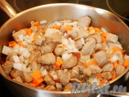 Лук и морковку нарезать на маленькие кубики, выложить к обжаренному мясу, перемешать и обжаривать 4-5 минут, периодически помешивая.
