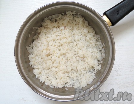 Рис хорошо промываем под проточной водой. В кастрюле доводим до кипения 500 миллилитров воды, солим, выкладываем промытый рис, даём закипеть, перемешиваем и варим на небольшом огне 10 минут (до полуготовности риса), затем воду сливаем. Рису даём остыть.