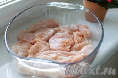 Филе курицы нарежьте тонкими пластинами толщиной около 1 см (можно дополнительно отбить его). Уложите кусочки на дно формы для выпекания, присыпав молотым перцем и солью.

