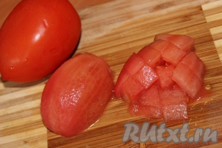 Помидоры ошпарить кипятком, снять кожуру и нарезать небольшими кусочками. Добавить кусочки помидора в сковородку к овощам, тщательно перемешать, посолить, поперчить по вкусу и тушить ещё минут 5.
