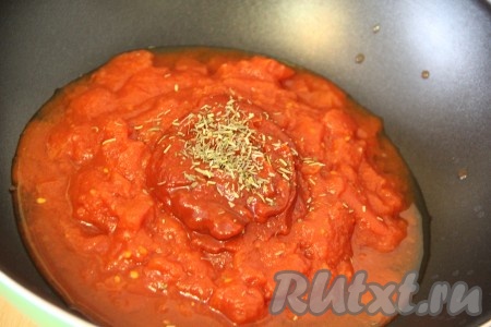 Пока жарится филе приготовим соус: в глубокую сковороду выкладываем помидоры в собственном соку, томатную пасту и щепотку трав. Если нет в наличии томатов в собственном соку, можно взять свежие помидорчики. Нужно их обдать кипятком, снять шкурку, а затем пробить блендером и вуа-ля томаты в собственном соку готовы. 