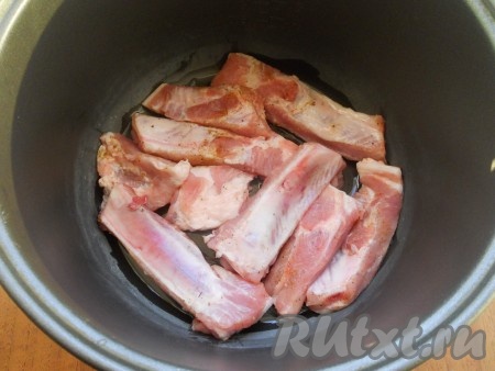 В чашу мультиварки влить растительное масло, выложить свиные ребра, немного их посыпать специями для мяса. Закрыть крышку. Выставить программу "Выпечка" на 40 минут. 
