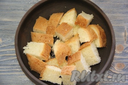  Дно жаропрочной формы слегка смазать оливковым маслом. Затем выложить кусочки хлеба. Хлеб можно нарезать на крупные квадратики или крупно поломать.