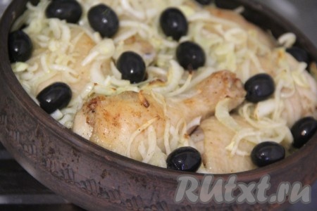 Через 20 минут достать курицу из духовки, выложить на неё лук и маслины, поставить форму обратно в духовку на 15-20 минут. 