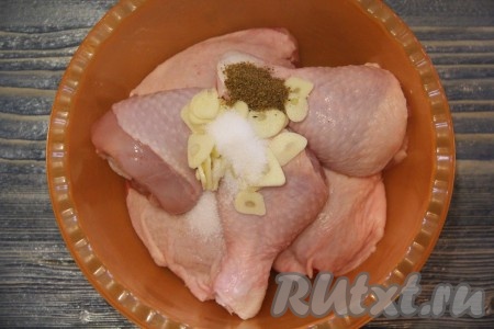 Чеснок почистить и нарезать тонкими лепестками. Добавить к кусочкам курицы соль, специи и чеснок.
