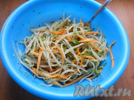 В салат из дайкона, огурца и моркови добавить измельченную петрушку и заправку, посолить по вкусу и перемешать.
