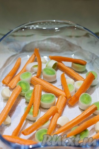 В форму для запекания выложите целые дольки чеснока, морковь, нарезанную брусочками (можно нарезать и по-другому, главное - не мельчить!) и лук-порей, нарезанный кольцами. 
