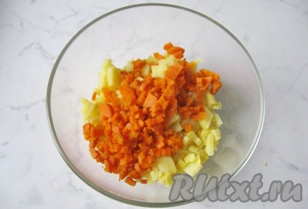 Одну морковь сварить до мягкости в кожуре, охладить, почистить и мелко нарезать. Добавить в салатник к картофелю.
