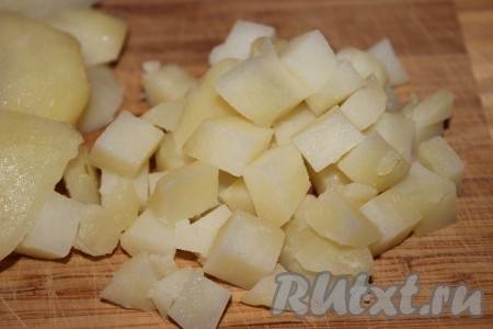 Картофель тщательно помыть при помощи щетки или губки, сложить в кастрюлю подходящего размера и залить холодной водой. Как только вода закипит, уменьшить огонь, накрыть кастрюлю крышкой и варить в течение 25-30 минут. Тут все зависит от сорта картофеля. Чтобы убедиться, что картофель готов, необходимо проткнуть его ножом или вилкой. Если картофелина легко проткнулась, значит - готова. Готовую картошку остудить, почистить и нарезать небольшими кубиками.
