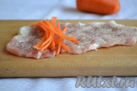 Очищенную морковь нарезать (или натереть) длинными полосками. Полоски моркови выложить на отбитые куски свинины и свернуть рулетиком.
