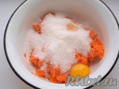 Переложить натёртую тыкву в глубокую в миску, добавить яйца и сахар, перемешать столовой ложкой.