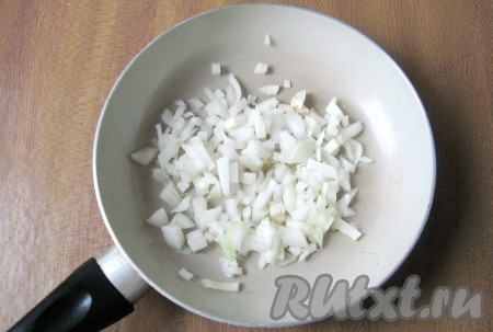 Репчатый лук почистить, помыть и мелко нарезать. Во второй сковороде прогреть растительное масло, выложить лук и обжарить его до прозрачности на сковороде (в течение 4-5 минут), периодически помешивая.