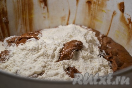 Сразу же всыпать муку, какао и разрыхлитель, перемешать шоколадное тесто столовой ложкой.