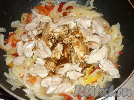 В сковороду с овощами добавить обжаренные кусочки курицы и получившийся соус.