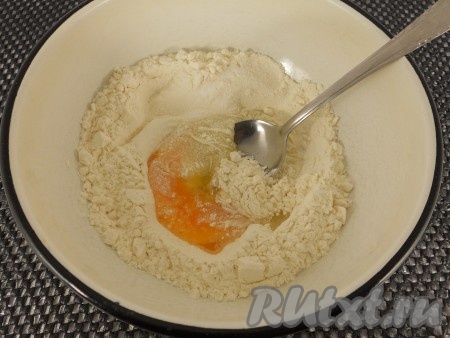 Прежде всего замесим тесто для вареников, для этого в миску нужно просеять 2 стакана муки, добавить соль, соду, сахар и сырое яйцо.