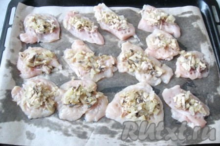 На каждый кусочек куриного филе выложить смесь грибов с луком.
