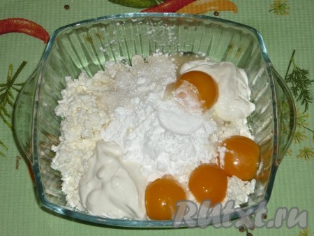 Яйца разделить на желтки и белки. Соединить творог с крахмалом, яичными желтками, сметаной и 5 столовыми ложками сахара. 
