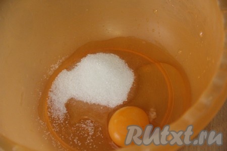 Соединить в объёмной миске яйцо с сахаром, слегка взбить венчиком.