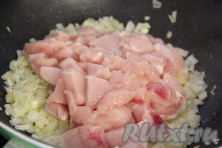  Добавить кусочки куриного мяса в сковороду с обжаренным луком и хорошо перемешать.
