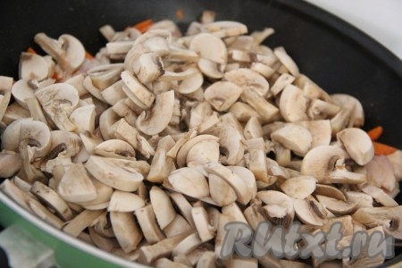 Добавить грибы в сковороду к куриному филе и моркови, тщательно перемешать.