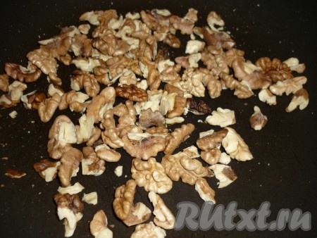 Грецкие орехи поджарить в течение 4-5 минут, помешивая, на сухой сковороде. С подсушенных орехов снять шелуху и немного измельчить.