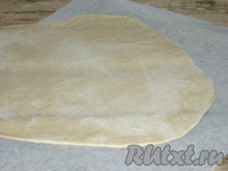 Каждую часть теста на слегка припылённой мукой поверхности раскатать в пласт толщиной 1-2 миллиметра. Пласт теста должен быть большего размера, чем форма, в которой вы будете выпекать сырный пирог.   