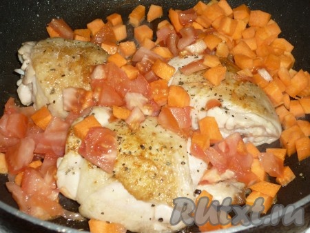 Морковь очистить и помыть, нарезать вместе с помидором на кубики среднего размера, добавить к курице.  