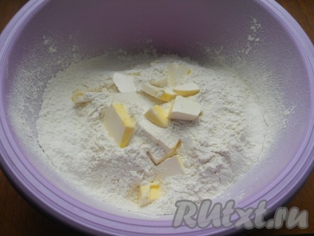 Приготовить тесто: в миску просеять муку, добавить разрыхлитель и холодное сливочное масло, нарезанное кусочками.
