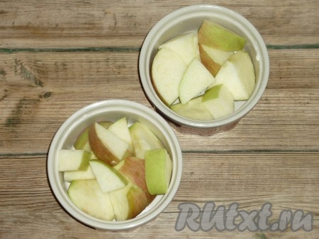 Яблочный крамбл я выпекала в порционных формочках, но можно взять и одну форму. Жаропрочные формочки смазать маслом. Выложить яблоки. 