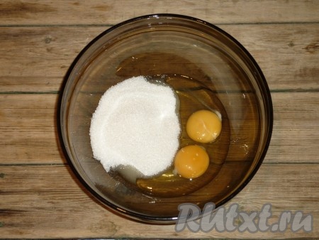 В небольшой ёмкости соединить кефир и соду, тщательно перемешать и оставить на 3-4 минуты. За это время сода полностью погасится в кефире и поверхность кефирно-содовой смеси покроется пузырьками, немного увеличится в объёме. В объёмной миске, в которой будет удобно взбивать миксером, соединить яйца с сахаром. 