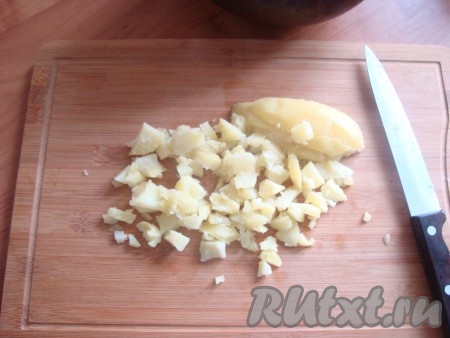 Картофель отвариваем в мундире. Чистим его и мелко режем кубиками. Отправляем тоже в горшок.
