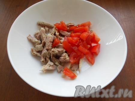 Вареное мясо нарезать небольшими кусочками и добавить к нему свежий помидор, нарезанный кубиками.
