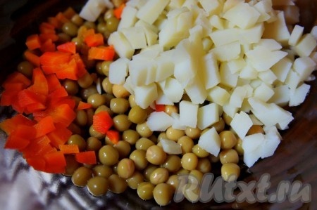 Картофель, отваренный в кожуре, остудить, очистить, нарезать на средние кубики и выложить в салат из моркови и горошка.
