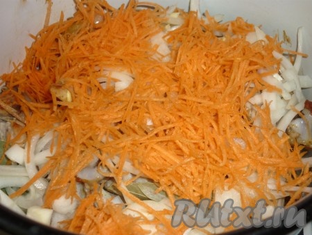 Обжаренные кусочки курицы переложить в кастрюлю, добавить лавровый лист, нарезанный полукольцами лук и натёртую на крупной тёрке морковь, посолить, поперчить.
