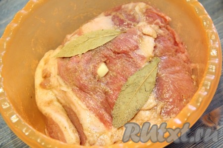 Сделав в свинине небольшие надрезы, нашпиговать мясо чесноком. Лавровый лист выложить на мясо.
