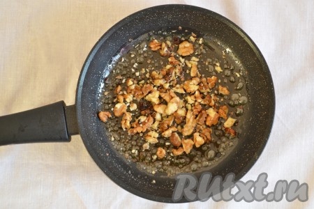 Грецкие орехи немного измельчить, добавить в сковороду с карамелью и перемешать.
