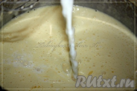 В смесь желтков и сахара добавить растопленное, слегка остывшее сливочное масло и тёплое молоко, перемешать.
