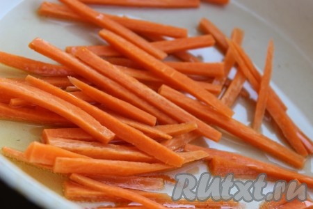 В сковороде разогреть небольшое количество растительного масла, выложить брусочки морковки и обжаривать на среднем огне в течение 3-4 минут, периодически помешивая.
